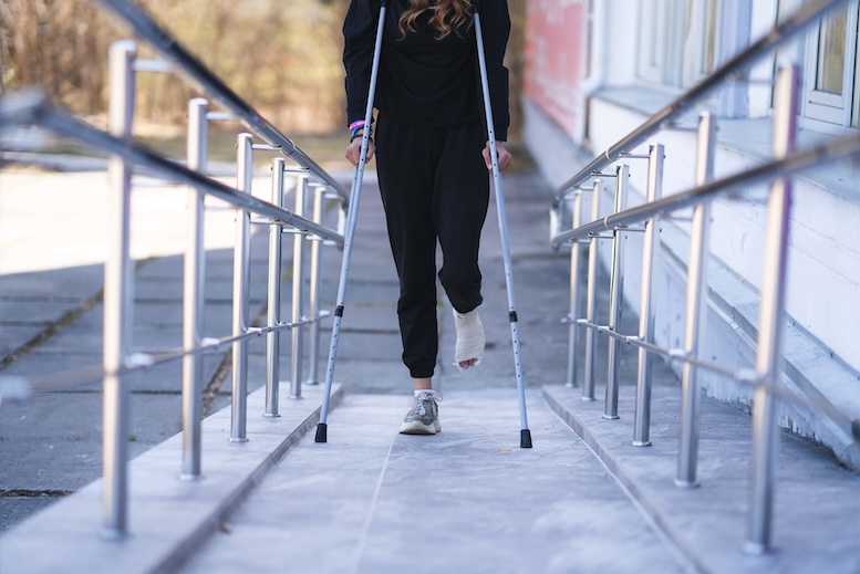 Mujer en muletas subiendo rampa